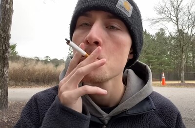 Лечение зависимости от табакокурения в СВАО Москвы Мужчина с сигаретой делает затяжку